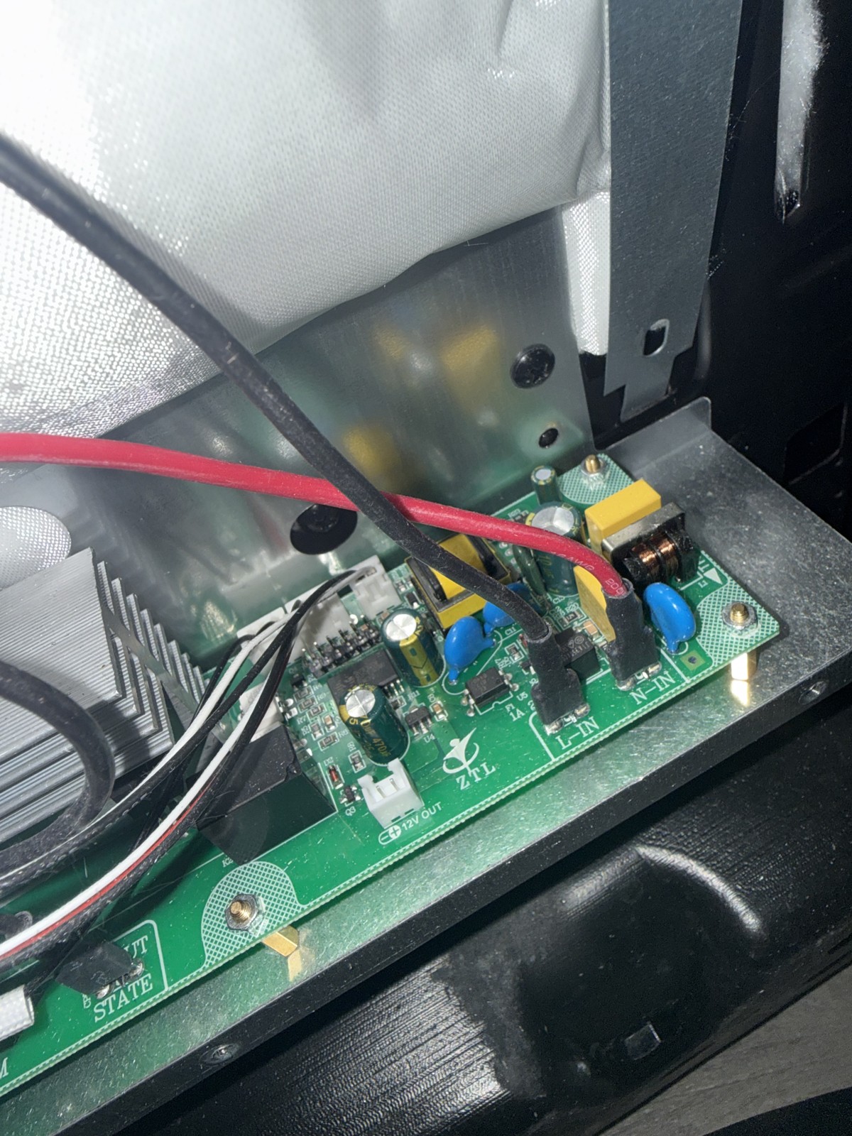 Appliance control board printed circuit board with capacitors and a heat sink, photographed during electronic diagnosis